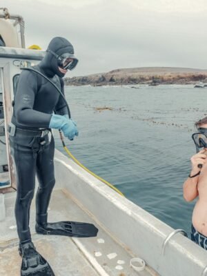 Man in Black Helmet Holding Black and Blue Stick Standing on Boat